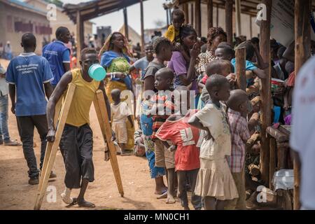 Ein deaktiviertes kongolesische Flüchtlinge gesehen, seine Lebensmittel behälter mit seinen Mund auf die Verteilung von Nahrungsmitteln an den Kyangwali Flüchtlingslager. Nach Angaben des UNHCR über 85.000 Menschen haben Uganda aus der Demokratischen Republik Kongo erreicht seit Anfang 2018 als sie entkommen Gewalt in der Provinz Ituri im Nordosten der ihren Krieg torned Land. Die Mehrheit der Flüchtlinge sind mit dem Schiff über den Lake Albert, die zwischen den beiden Ländern besteht. Mit Flüchtling Siedlungen in Uganda fast mit maximaler Kapazität gibt es Pläne für neue Siedlungen zu bauen, zu beschäftigen. Stockfoto