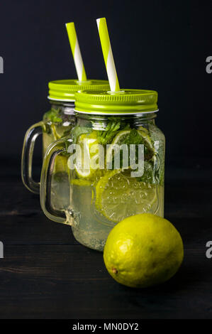 Mojito Cocktail mit Limetten und Minze in einem Glas auf einem dunklen Hintergrund. Sommer alkoholfreies Getränk Stockfoto