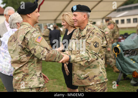 Brig. Gen. Steven Ainsworth, rechts, schüttelt Hände mit Command Sgt. Maj. Raymond braun Mitte, nach der 7. Mission unterstützt den Befehl Ändern des Befehls Zeremonie Aug 4, 2017 auf daenner Kaserne in Kaiserslautern, Deutschland. Ainsworth drehte das Kommando über nach Brig. Gen. Frederick R. Maiocco Jr. während der Zeremonie. Stockfoto