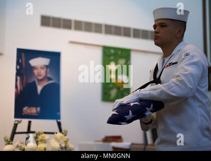 170805-N-AV 234-0088 (5. August 2017) Pearl Harbor Seaman Recruit Peter Acosta hält die Fahne der alten Herrlichkeit vor einem Porträt der späten Senior Chief kulinarische Spezialist Mandy Pante Francisco während einer Trauerfeier am Joint Base Pearl Harbor-Hickam's Kapelle statt. Francisco verstarb am Morgen des 23. Juli 2017. Er wird von seiner Frau und zwei Kindern überlebt. Stockfoto