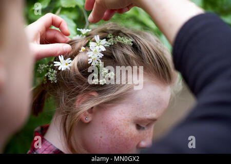 Ein junges Mädchen hat der Frühling Blumen in der geflochtene Haare platziert Stockfoto