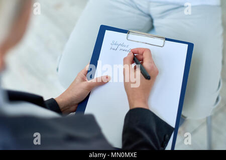 Erntegut Schuß von oben der Arzt Notizen des älteren Patienten Beschwerden in betreutes Wohnen zu Hause aus arbeiten. Stockfoto