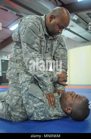 Armee-reservesoldat 1 st. Lt. Robert Sommer, Operations Officer, 335.- Signal (Theater) beauftragt ein Soldat auf, wie man einen Gegner werfen, wenn sie in einem vollen während einer combatives Übung auf Joint Base Mc Guire-Dix - Lakehurst, New Jersey, Aug 7. Mehr als 100 Soldaten aus der Armee finden 335 SC (T) Sitz in East Point, Georgien sind an der Basis die Durchführung einer Vielzahl von Übungen im Rahmen der jährlichen Schulung der Einheit. (Offizielle US-Armee finden Foto von SPC. Matthew E. Drawdy) Stockfoto