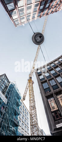 Baukran über Hochhäuser, Stockholm, Schweden. Ansicht von unten Stockfoto