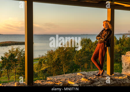 Eine Frau beobachtet den Sonnenuntergang auf der Ostsee in Saaremaa, Estland Stockfoto