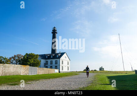 Eine Frau geht in Richtung Sõrve Leuchtturm in Saaremaa, Estland Stockfoto