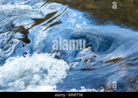 Wasser in einem Fluss wirbelnden und Hetzende über Felsen, ruhig auf der einen Seite und turbulenten auf der anderen. Stockfoto