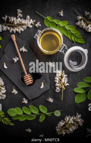 Akazien Honig im Glas auf schwarzem Hintergrund Stockfoto