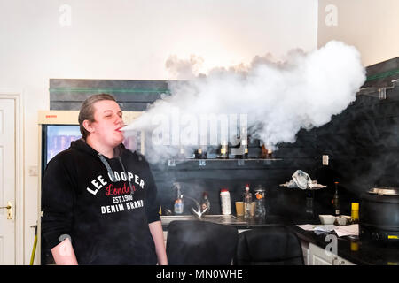 Die jungen Menschen demonstrieren vaping innerhalb einer vaping Shop Stockfoto