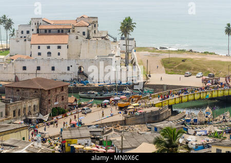 Elmina, Ghana - 13. Februar 2014: Bunte günstig Holz Fischerboote und historischen kolonialen Burg in afrikanischen Hafenstadt Elmina Stockfoto