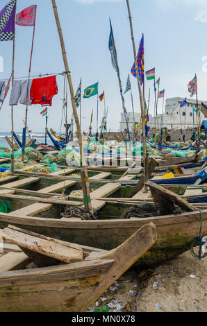 Cape Coast, Ghana - 15. Februar 2014: Bunte günstig Holz Fischerboote in den afrikanischen Harbour Town Cape Coast mit kolonialen Schloss im Hintergrund Stockfoto