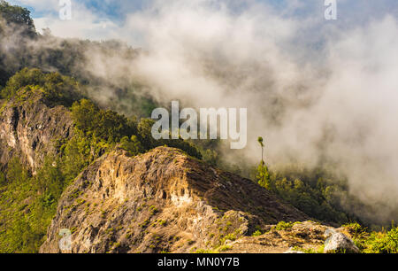 Wolken über dem Wald Berg. Nebel beginnt zu bilden, wie die Sonne über zwei kraterseen am Kelimutu Nationalpark in Ost Nusa Tenggara, Indonesien steigt. Stockfoto