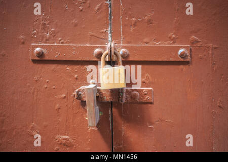 Holz-, braunen Tür Hintergrund mit zwei Vorhängeschlössern abgeschlossen. Verbrauchtes Eingang bietet Sicherheit und Privatsphäre. Nahaufnahme mit Details. Stockfoto