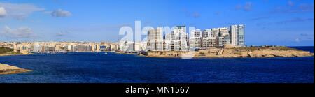 Malta, Valletta. Stadt Sliema mit mehrstöckigen Gebäuden direkt am Wasser, dem blauen Meer und blauer Himmel mit einigen Wolken Hintergrund. Panoramaaussicht, Banner. Stockfoto