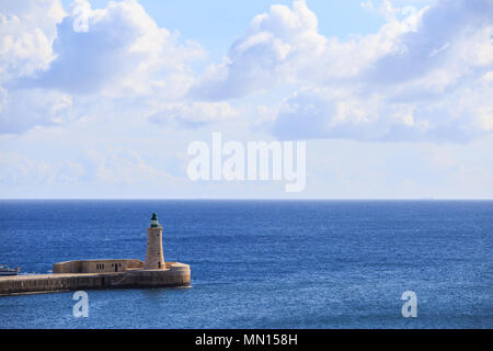 St. Elmo's Leuchtturm in Valletta, Malta. Mole Grand Harbour zwischen blauem Meer und bewölkter Himmel Hintergrund. Stockfoto