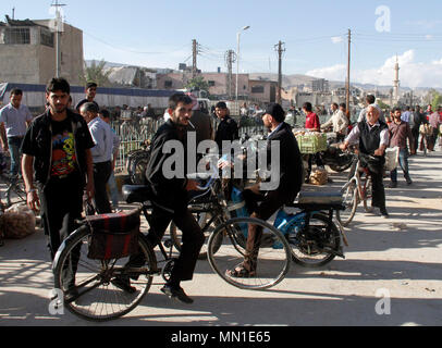 Damaskus, Syrien. 13. Mai, 2018. Syrer fahren Fahrräder in Douma Bezirk, östlich von Damaskus, Syrien, am 13. Mai 2018. In der ehemals von den Rebellen gehaltenen Stadtteil Douma, Fahrzeuge mit kein Kraftstoff wurde während des Krieges, der Menschen zu Fahrräder als alternative Transportmittel geschoben menschenleer. Credit: Hummam Sheikh Ali/Xinhua/Alamy leben Nachrichten Stockfoto