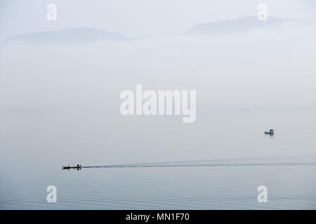 Huangshan, Anhui Chinas Provinz. 14 Mai, 2018. Angeln Boote segeln auf der Taiping See durch Nebel in Beijing ummantelt, der ostchinesischen Provinz Anhui, 14. Mai 2018. Credit: Zhang Duan/Xinhua/Alamy leben Nachrichten Stockfoto