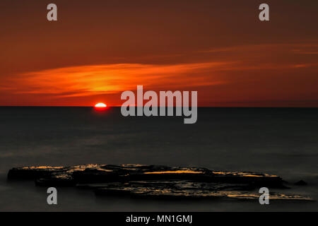 Trow, South Shields, Großbritannien. 14 Mai, 2018. Einen herrlichen Sonnenaufgang kriecht über den Horizont mit Aussicht auf die Nordsee. Mit dem Felsen von Graham's Sand in den Vordergrund. Credit: Dan Cooke/Alamy Nachrichten Stockfoto