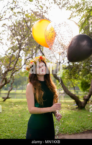 Junge schöne Frau Abschluss feiern im Park in Bang Stockfoto