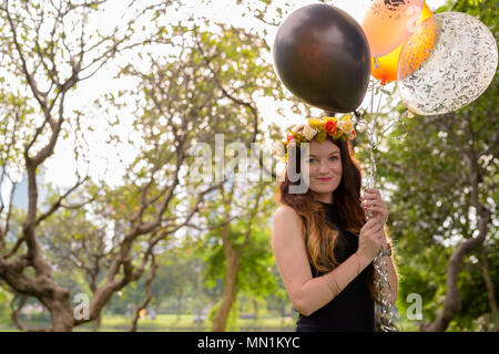 Junge schöne Frau Abschluss feiern im Park in Bang Stockfoto