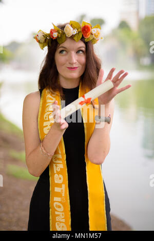 Junge schöne Frau Abschluss feiern im Park in Bang Stockfoto