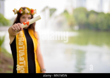 Junge schöne Frau Abschluss feiern im Park in Bang Stockfoto
