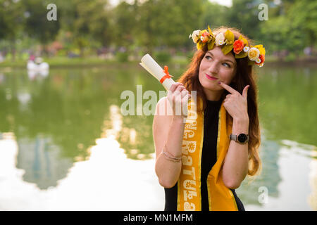 Junge schöne Frau Abschluss feiern im Park in Bang Stockfoto