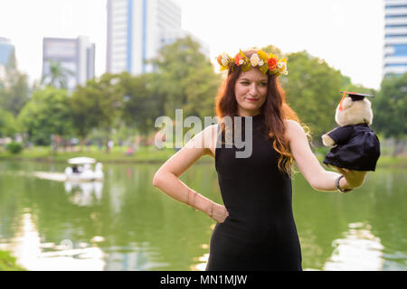 Junge schöne Frau Abschluss feiern im Park in Bang Stockfoto