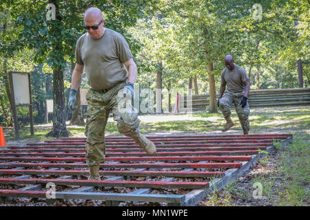 Armee finden Generalmajor Peter A. Bosse (vorne), Kommandierender General, 335.- Signal (Theater) und Command Sgt. Maj. Ronnie Bauer, command Sergeant Major, 335 SC (T), durch das Labyrinth Hindernis im Parcours laufen auf Joint Base Mc Guire-Dix - Lakehurst, New Jersey 12.08.10. Mehr als 100 Armee-reserve Soldaten aus der Zentrale und die Konzernzentrale, 335 SC (T), mit Sitz in East Point, Georgia neun Tage auf der gemeinsamen Basis thier Soldat Fähigkeiten durch eine Vielzahl von Schulungen als Teil der Einheiten das jährliche Training verbracht. (Offizielle U.S. Army Reserve Foto von Sgt. 1. Klasse Bren Stockfoto