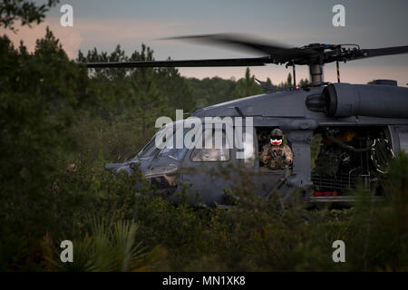 Eine spezielle Missionen aviator vom 41. Rescue Squadron Scans für Bedrohungen bei der Suche und Rettung, die im Rahmen der Stealth Guardian, 10.08.2017, in der Apalachicola National Forest, Fla. Stealth Wächter erlaubt 5. Generation Kämpfer in Air Force schnelle Rettung Funktionen während einer 5-tägigen Übung zu integrieren. (U.S. Air Force Foto: Staff Sgt. Ryan Callaghan) Stockfoto