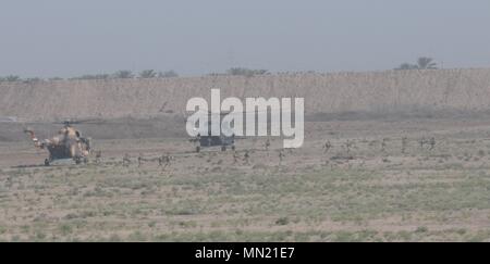 Die irakischen Sicherheitskräfte sind auf ein Ziel, das irakische Armee aviation Mi-17 Hubschrauber eingesetzt, bevor eine Security Perimeter während der Antenne Response Force Übung an Taji militärische Komplex, Irak, August 13,2017. Die ISF zur Verfügung gestellt, um die Sicherheit zu einem HH-60M Black Hawk Hubschrauber, der durch simulierte Wartungsarbeiten geerdet wurde. Die Schulung ist Teil des gesamten Combined Joint Task Force - inhärenten Building Partner Kapazität mission lösen, die über die Ausbildung und die Verbesserung der Fähigkeit der zusammengeschlossen, um Kräfte, die ISIS konzentriert. CJTF-OIR ist die globale Koalition zu besiegen Stockfoto