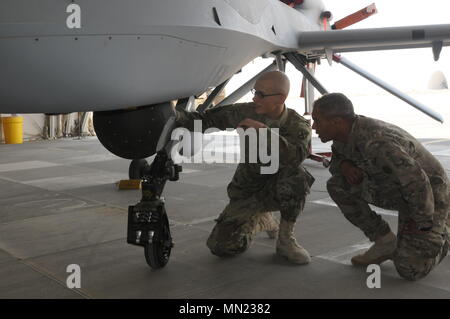 ALI AL SALEM AIR BASE, Kuwait-SPC. William Dopp, ein Unmanned Aircraft Systems Betreiber von Unternehmen D, 10 Aviation Regiment, 10 Mountain Division, bietet Informationen über die MQ-1C Grau Adler zu Lt Gen Michael Garrett, der kommandierende General der US Army Central, bei seinem offiziellen Besuch im Ali Al Salem Air Base, Kuwait, August, 11, 2017. D Co. bietet Unterstützung, um den Betrieb Spartan Shield durch Schulungen Flüge und Cross Training mit anderen Einheiten mit Bereitschaft im gesamten ARCENT von Operationen zu verbessern. (US Army Foto: Staff Sgt. Isolda Reyes) Stockfoto