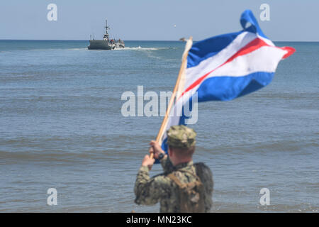 170816-N-TP 832-070 JACKSONVILLE, Fla. (Aug. 16, 2017) der Bootsmann Mate 3. Klasse William Wetzel, zugeordnet zu den Commander Naval Beach Group (CNBG) 2, zusehen, wie eine Leichterung system Causeway Fähre zugeordnet Beach Master Unit (BMU) 2 Ansätze für einen Strand Landung als Teil eines maritimen Vorpositionierung Kraft ausüben (MPFEX). Die Übung ist darauf ausgerichtet, die Mannschaft zu bieten die Möglichkeit, auspacken Praxis und Vorbereitung ein Schiff voll mit Ausrüstung und Transport zum Strand zu re-Versorgung von Bodentruppen. (U.S. Marine Foto von Mass Communication Specialist 3. Klasse Michael Lopez/Freigegeben) Stockfoto
