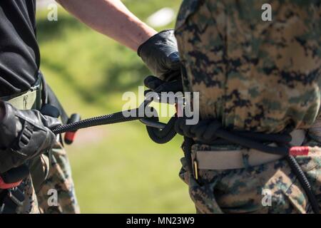 Ein Feld Ausbildung Instructor zieht ein rekrut der Sicherheitsgurt vor dem Rekrutieren rappels Aug 1, 2017, auf Parris Island, S.C. Rekruten rappel aus dem 47 m hohen Turm tragen ein Gurt, Helm und Handschuhe, Vertrauen zu gewinnen und keine Höhenangst zu überwinden. Beide Unternehmen sind zu graduieren, Sept. 22, 2017 geplant. Parris Island ist der Aufstellungsort des Marine Corps, Ausbildung rekrutieren seit Nov. 1, 1915. Heute, rund 19.000 Rekruten kommen auf Parris Island jährlich für die Chance, United States Marines werden durch dauerhafte 12 Wochen der Strenge, transformative Training. Parris Island i Stockfoto