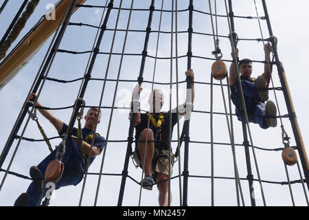Die USCGC Eagle (WIX-327) ist eine 295 Fuß lange Barke mit Stahlhüllen, die von der United States Coast Guard als Segelschulschiff betrieben und 1936 als Horst Wessel in Betrieb genommen wurde. Das Archivbild zeigt Besatzungsmitglieder, die die Takelage während einer Fahrt im Atlantischen Ozean auf dem Weg zum Homeport des Schiffes in Baltimore am 14. August 2017 kletterten. Stockfoto