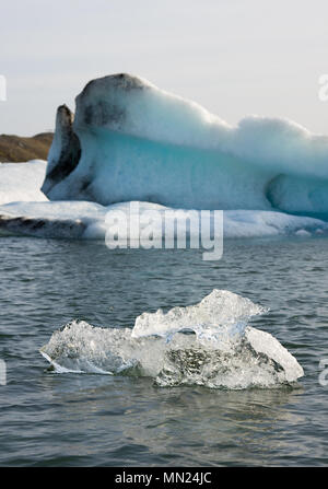 Ein kleiner Eisberg vor einem großen, Island. Stockfoto