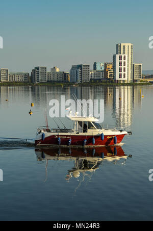 Ein kleines Fischerboot mit Menschen an Bord Kreuzfahrt in der Bucht von Cardiff im Morgenlicht Stockfoto