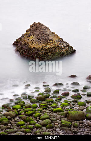 Lange Belichtung geschossen von einem basaltfelsen Bildung und Grün überwachsenen Felsblöcken, Island. Stockfoto