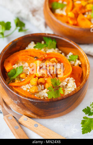 Vegan gesunde Schüssel mit braunen Reis, gebackener Kürbis und Kichererbsen. Vegetarisches Essen Konzept. Stockfoto