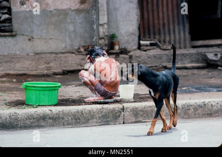 Managua, Nicaragua, Juni 1986. Orientalischer Markt, ein Junge wäscht sich mit einer Schale und Schüssel mit Wasser durch seine Heimat. Stockfoto