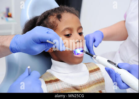 Einen dunkelhäutig Baby Mädchen im Stuhl des Zahnarztes Stockfoto