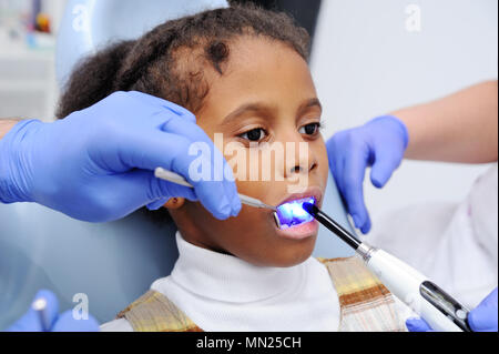 Einen dunkelhäutig Baby Mädchen im Stuhl des Zahnarztes Stockfoto