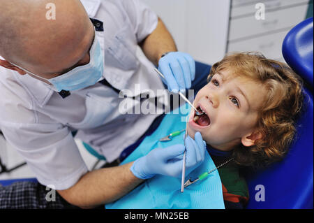 Männliche Zahnarzt untersucht einen jungen Patienten Stockfoto