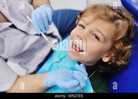 Männliche Zahnarzt untersucht einen jungen Patienten Stockfoto