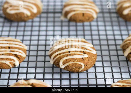 Frisch gebackene, hausgemachte pumpkin Spice Cookies, mit Ahorn Vereisung. Diese Gluten und ohne Milchprodukte Kekse sind auf einem Gitter angezeigt. Stockfoto