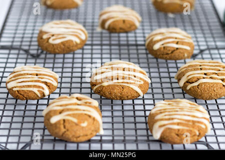 Frisch gebackene, hausgemachte pumpkin Spice Cookies, mit Ahorn Vereisung. Diese Gluten und ohne Milchprodukte Kekse sind auf einem Gitter angezeigt. Stockfoto