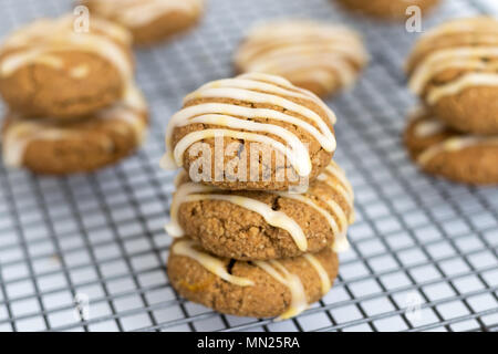 Frisch gebackene, hausgemachte pumpkin Spice Cookies, mit Ahorn Vereisung. Diese Gluten und ohne Milchprodukte Kekse sind auf einem Gitter angezeigt. Stockfoto