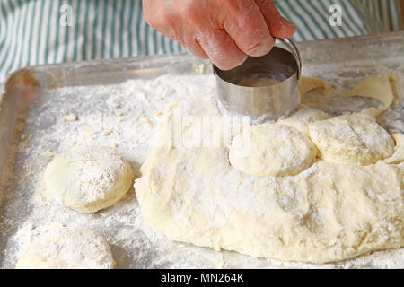 Ein männlicher Koch schneidet aus Keksen auf einer bemehlten Pan Stockfoto