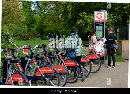 Touristen wählen Sie ein Fahrrad an eine Docking Station im Zentrum von London, Kensington Park Stockfoto