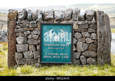 Yorkshire Dales National Park Boundary Zeichen auf eine dekorative stein Wand zwischen zwei alte steinerne Tor Beiträge gebaut Stockfoto